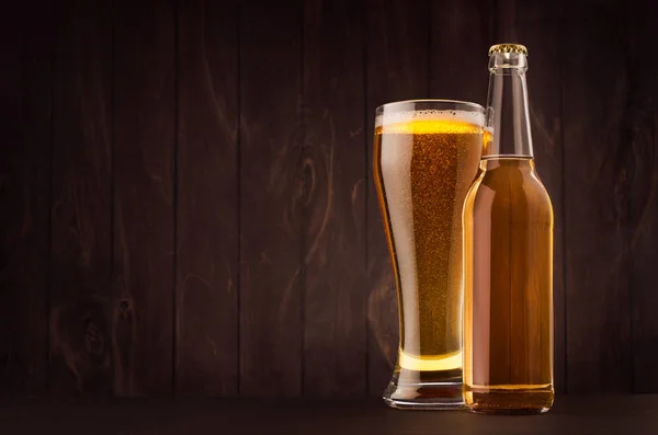 Прозора пляшка пива та склянка з золотим лайном на дошці з темно-коричневого дерева, копіювання простору, сміх. Шаблон для реклами, дизайну, фірмового стилю . — стокове фото