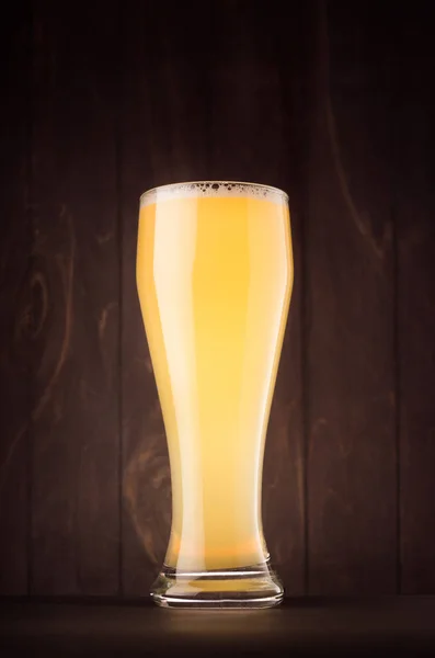 Gelas bir dengan lumpur weizen di papan kayu gelap, vertikal . — Stok Foto