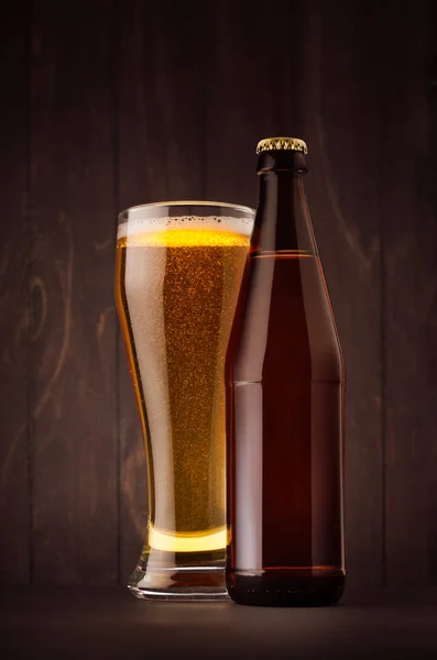 Коричнева пляшка пива NRW і склянка з золотим лайном на дошці з темного дерева, вертикально, сміється . — стокове фото