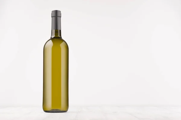 Botella de vino verde con vino blanco sobre tabla de madera blanca, maqueta . — Foto de Stock