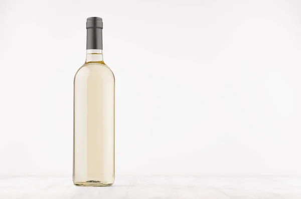 Прозрачная бутылка вина с белым вином на белой деревянной доске, макет . — стоковое фото