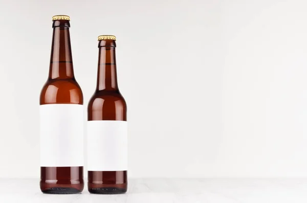 Brown beer bottles longneck 500ml and 330ml with blank white label on white wooden board, mock up. — Stock Photo, Image