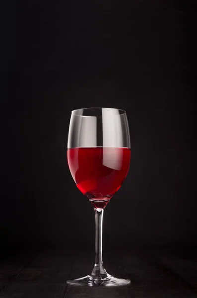 Copa de vino con vino rosa sobre fondo de madera negro oscuro elegante, espacio para copiar, vertical . —  Fotos de Stock