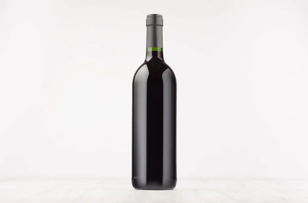 Bottiglia di vino nero con vino rosso su tavola di legno bianco, mock up — Foto Stock