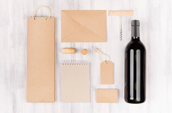 Corporate Identity-Vorlage für die Weinindustrie, braune Kraftverpackungen, Schreibwaren, Merchandise-Set mit Flasche Rotwein auf weichem weißem Holzhintergrund. — Stockfoto