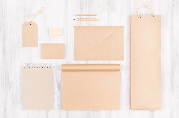 Corporate Identity Vorlage; Verpackung, Schreibwaren, Geschenkattrappe aus braunem Kraftpapier auf weichem weißem Holzhintergrund. — Stockfoto