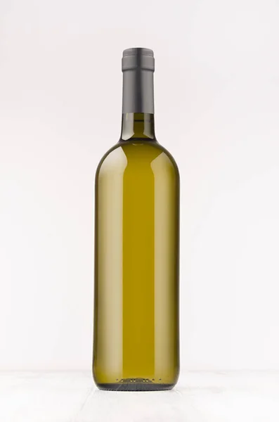 Botella de vino verde con vino blanco sobre tabla de madera blanca, maqueta, vertical . — Foto de Stock