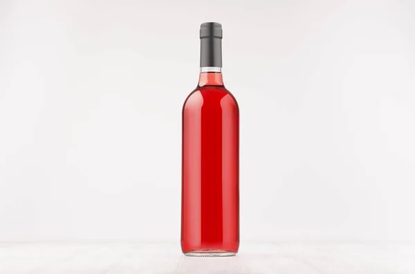 stock image Wine bottle with rose wine on white wooden board, mock up. 