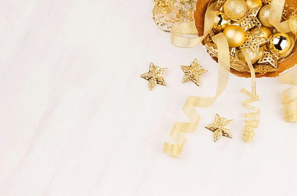 Christmas decorations, gold stars, balls and ribbons on soft white wooden background, copy space. — Stock Photo, Image