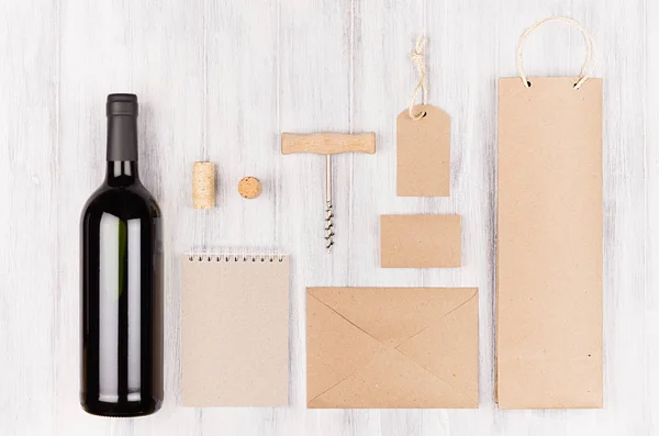 Corporate Identity Vorlage für die Weinindustrie, leere beige Kraftverpackungen, Schreibwaren, Merchandise-Set mit Flasche Rotwein auf weichem weißem Holzhintergrund. — Stockfoto