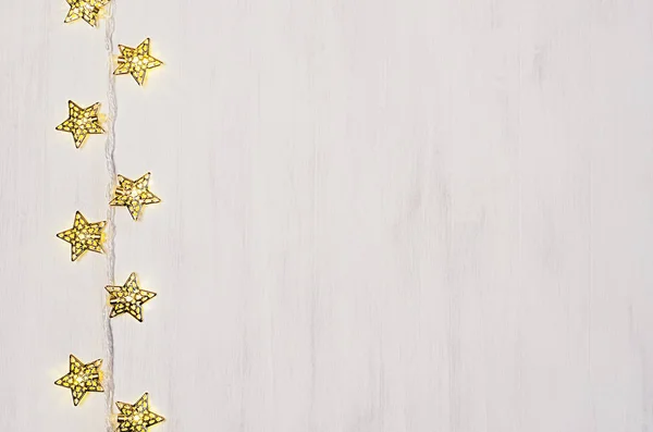 Fun festive lights yellow stars burn on soft beige wood board. — Stock Photo, Image