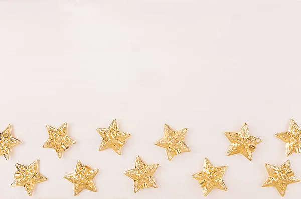 Gold stars on white wooden background. Top view, copy space. — Stock Photo, Image