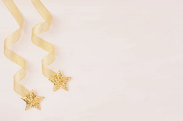 Curl ribbon and gold stars falling on soft white wooden background. — Stock Photo, Image