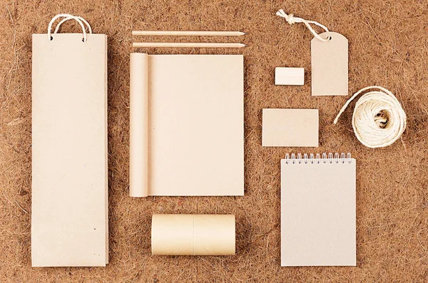 Eco embalaje en blanco, papelería, plantilla de regalos de papel kraft sobre fondo de fibra de coco marrón . — Foto de Stock