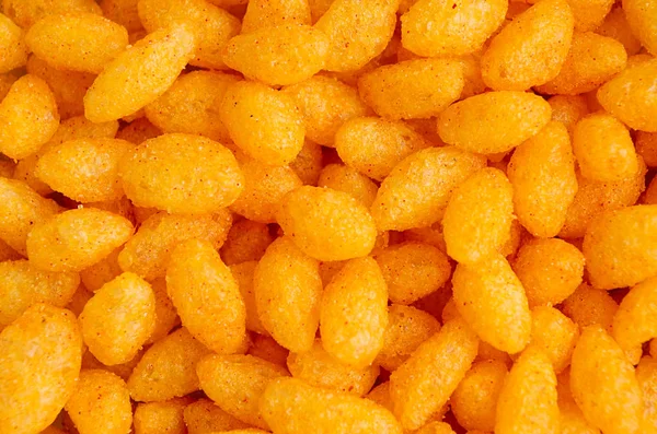 パフィー オレンジ コーン スティック唐辛子クローズ アップ トップ ビュー ファーストフードの背景 — ストック写真