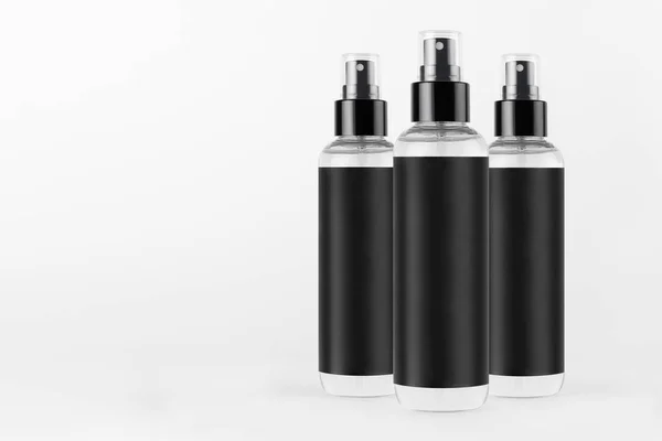 Three Tall Transparent Spray Dispenser Bottles Cosmetics Black Label White — Stockfoto