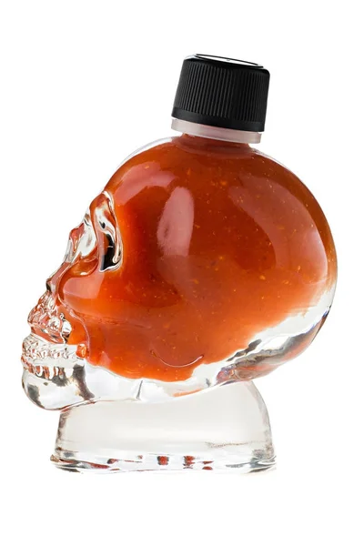 Sauce chili piquante dans un verre en forme de crâne sur fond blanc — Photo