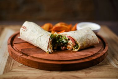 Tahta tavukla, sebzeyle ve kızarmış patatesle doldurulmuş tortilla servis ediliyor.