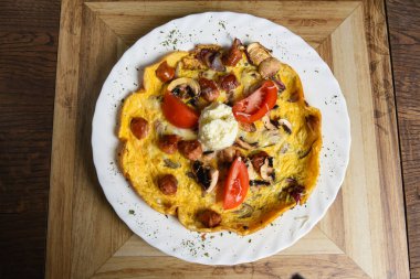 Sosisli, mantarlı ve soğanlı omlet.