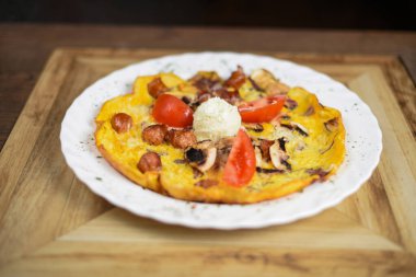 Sosisli, mantarlı ve soğanlı omlet.