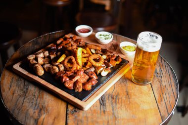 Sosis ve patatesle servis edilen restoran tabağı.