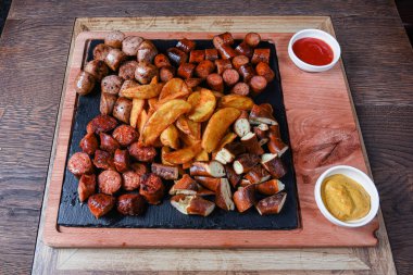 Sosis ve patatesle servis edilen restoran tabağı.