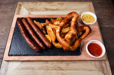 Sosis ve patatesle servis edilen restoran tabağı.