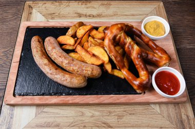 Sosis ve patatesle servis edilen restoran tabağı.