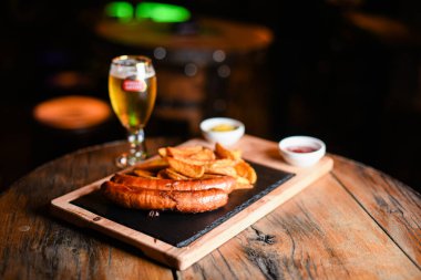 Sosis ve patatesle servis edilen restoran tabağı.