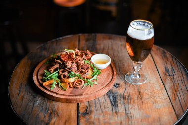 Kalamar halkaları ve patateslerle servis edilen restoran tabağı.