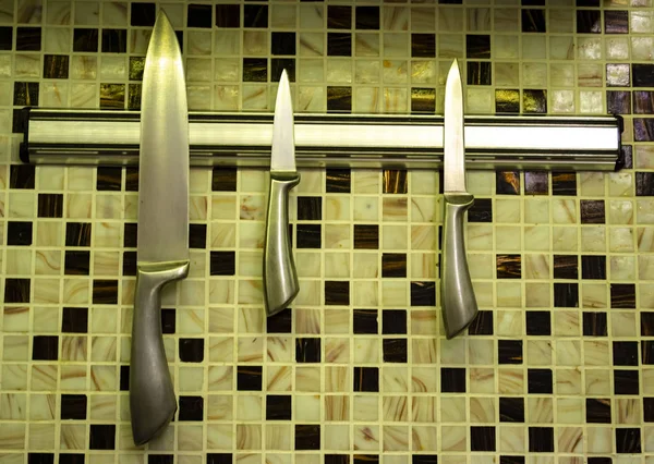 Кухонные ножи на магнитном держателе крупным планом — стоковое фото