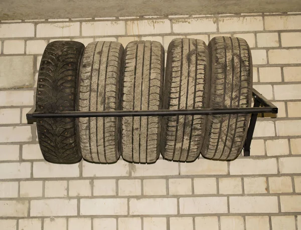 Cinq pneus de voiture dans le garage sur le mur — Photo