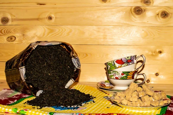 Вид кубков с черным чаем и сахаром на деревянном фоне — стоковое фото