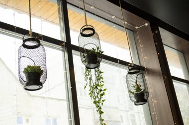 Çiçekler sokak kafesinin dış tarafında asılı.