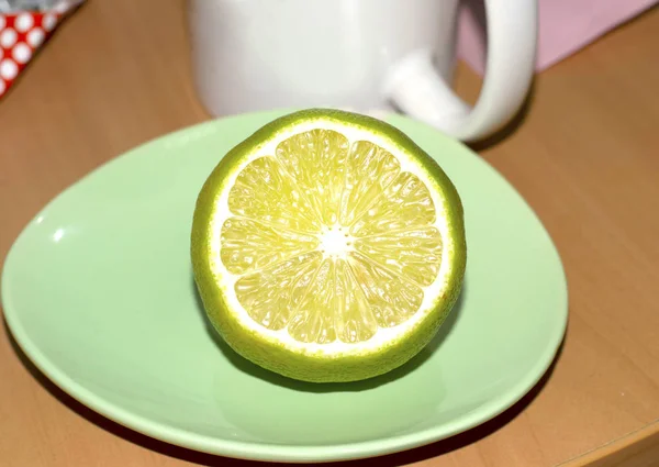 Cop of tea with green lemon on plate — Stock Photo, Image