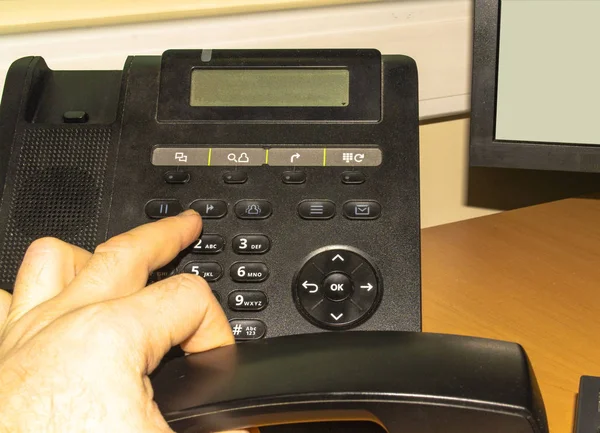 Dialing number a phone in a office by man hand — 스톡 사진