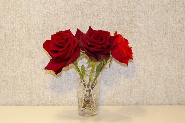 Drei rote Rosen im Glasbecher — Stockfoto