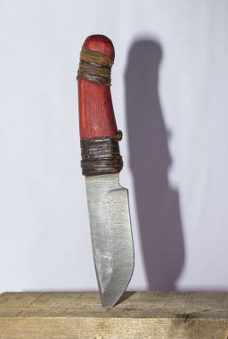 Damascus knife stuck in the wooden board