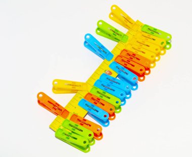 close-up multi-colored linen clips attached to a ruler on a whit