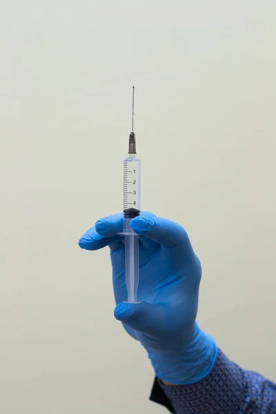 Visning av läkare som håller sprutan med injektion på grå bakgrund — Stockfoto