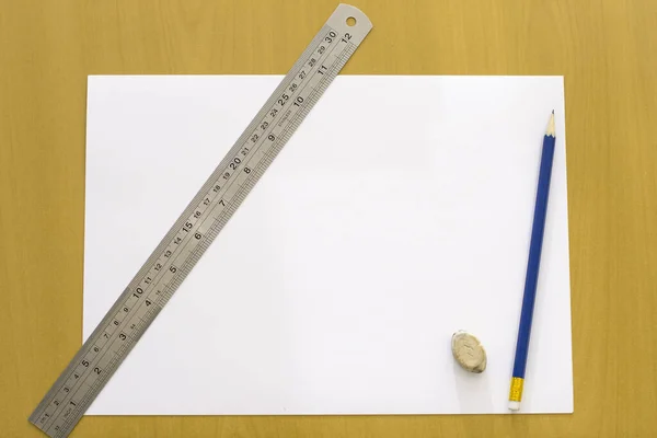 用铅笔和尺子在木制桌面上打开空白纸 — 图库照片