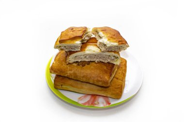 Tabakta lezzetli etli turtalar. Beyaz bir masada fırından yeni çıkmış.