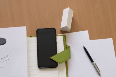 Masadaki iş hayatı konsepti akıllı telefon defteri kâğıdı beyaz ev modeli. Üst Manzara. tahta arkaplan
