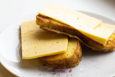 Tabakta peynir olan kızarmış beyaz ekmek dilimleri. Yan görünümü kapat.