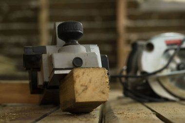 İnşaat alanında, zeminde elektrikli bir planör ve elektrikli testere var. Ahşap bir evde onarım