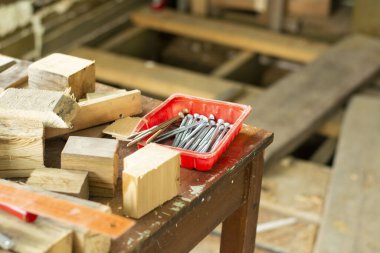 Ahşap bir evin iç yapısı. Kırmızı plastik bir kutuda uzun vidalar