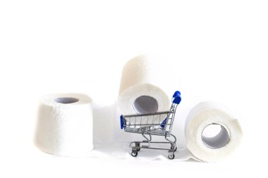 Tüketici paniğinin sembolü olarak üç rulo tuvalet kağıdı ve tekerlekli bir alışveriş arabası. üst görünüm yakın plan. 
