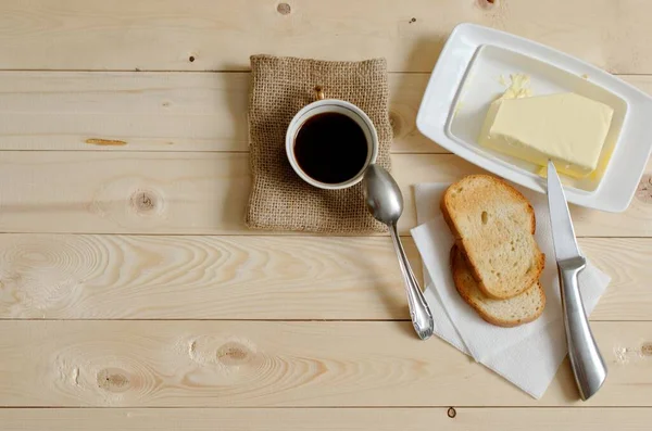 early morning cup of coffee and toasters with butter. invigorating breakfast. wooden table as background