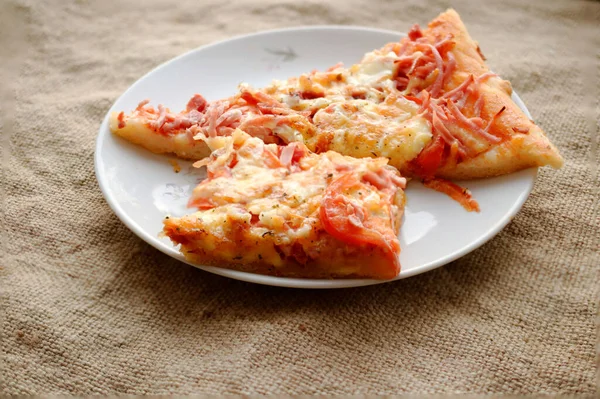 Twee Plakjes Zelfgemaakte Pizza Een Bord Jute Achtergrond — Stockfoto