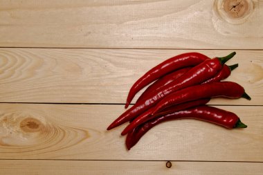 Ahşap bir arka planda kırmızı biber demeti. Yukarıdan bak. Model modeli. Kopyalama alanını kapat